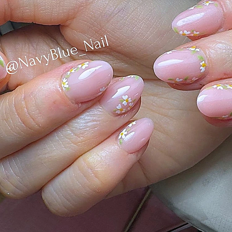 Uñas almendradas rosa con florecitas de colores y detalles dorados