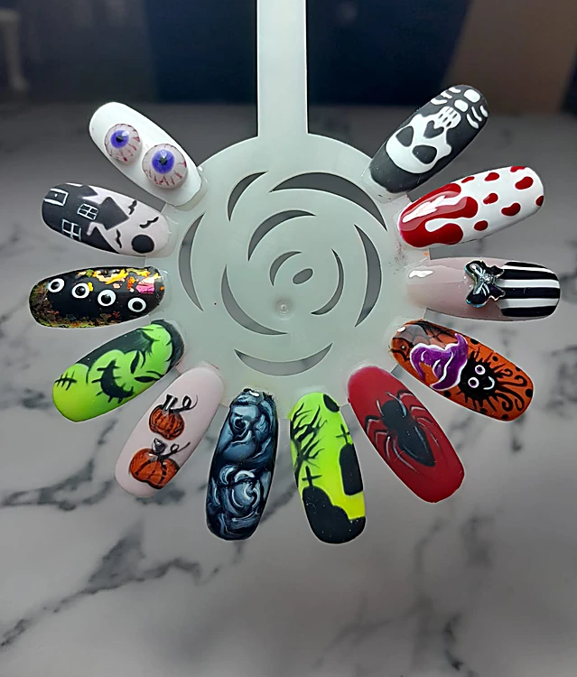 Muestrario en forma de rosa con uñas de Halloween: ojos, calabazas, telarañas, gotas rojas y rayas